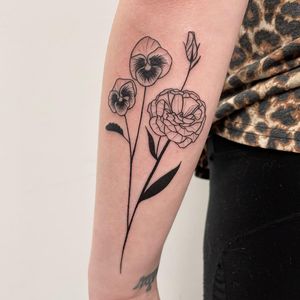 Beautifully detailed flower tattoo on forearm by Nic V. Perfect for those who appreciate intricate blackwork style.