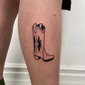 Unique and intricate blackwork tattoo on lower leg featuring a detailed boot pattern, by artist Nic V.