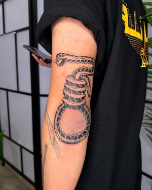 Get a bold and unique blackwork snake design by Sasha on your upper arm. Elevate your tattoo game with this edgy and eye-catching piece.