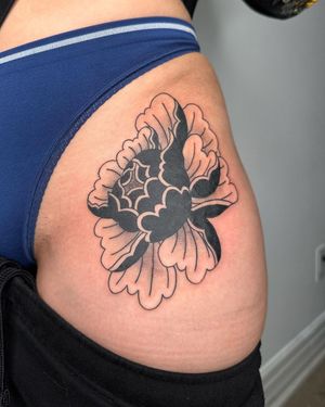 A beautiful blackwork peony flower tattoo on the hip, expertly done by Sasha. Enhance your feminine grace with this stunning design.