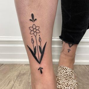 Get a stunning blackwork flower tattoo on your lower leg by the talented artist Nic V. Enjoy a beautiful and unique design that will last a lifetime.