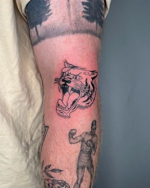 Experience the power and grace of a fierce tiger brought to life in stunning illustrative style by Sasha on your upper arm.