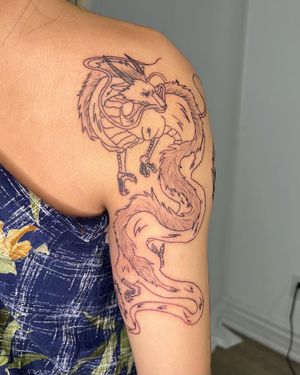Illustrative dragon design on shoulder by talented artist Sasha, featuring intricate fine line work.