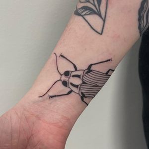 Get inked with a stunning blackwork beetle design by Nic V on your forearm. Stand out with this unique and intricate tattoo!