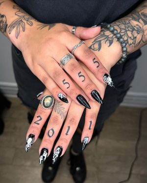 Get a sleek and stylish fine line number tattoo on your finger by Sasha. Perfect for those who love small lettering designs.