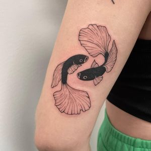Nic V's stunning blackwork fish tattoo, beautifully designed to adorn your upper arm. Dive into the depths of artistry with this unique piece.