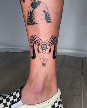 Get a unique fine line tattoo on your lower leg featuring a skull, horns, pentagram, and name by talented artist Sasha.