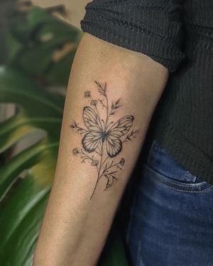 Beautiful illustrative tattoo featuring a delicate butterfly and flower, done by Fabian Lopez Barreda.