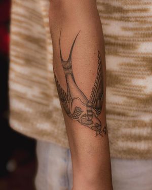 Blackwork forearm tattoo featuring a beautiful illustration of a bird and woman, created by Fabian Lopez Barreda.