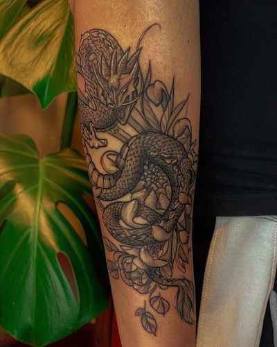 Stunning blackwork with an illustrative style, featuring a fierce dragon intertwined with a delicate flower, by artist Fabian Lopez Barreda.