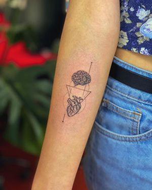 Fine line blackwork tattoo on forearm by Fabian Lopez Barreda combining heart, triangle, and brain motifs in a geometric pattern.