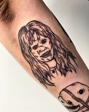 Get possessed by horror with this striking forearm tattoo by Miss Vampira, featuring Regan from the Exorcist as the devil.