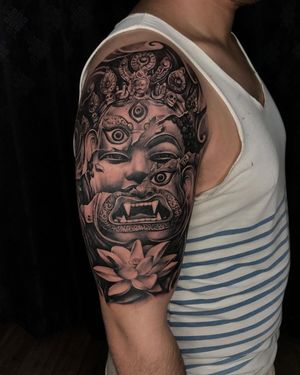 Experience peace and power with Avi's stunning black and gray realism tattoo featuring Buddha and Kali motifs.