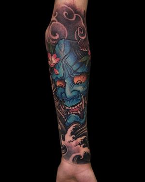 Experience the striking beauty of traditional Japanese art with this illustrative sleeve tattoo featuring a hannya mask, flower, and swirling clouds. Created by the talented artist Avi.