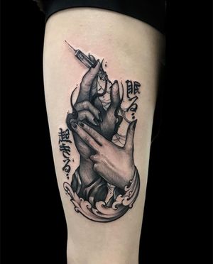 Stunning black and gray design by Avi featuring intricate details of a hand holding a syringe, Japanese Kanji characters, and waves on the arm.