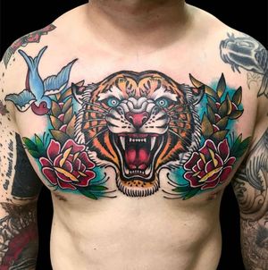 Get a fierce yet delicate traditional tiger and rose tattoo on your chest by the talented artist Avi.