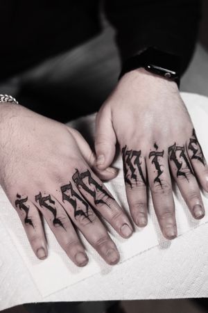 Unique blackwork design by Alejandro Gonzalez featuring a pattern and meaningful lettering on the finger.