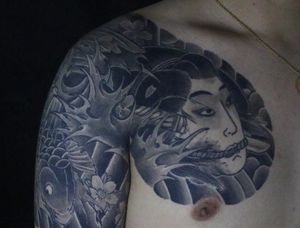 Unique chest tattoo combining traditional Japanese geisha and severed head motifs by Hansol Jung.