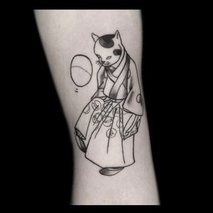 Experience the unique fusion of traditional Japanese style and modern blackwork with this striking and detailed cat tattoo by renowned artist Drone.