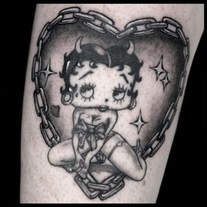 Illustrative blackwork of Betty Boop surrounded by hearts and chains on forearm. By Drone.