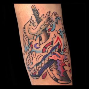 A striking illustrative tattoo featuring a fierce dragon wrapped around a sword, skillfully done by the talented artist Drone.