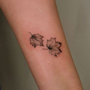 Blackwork leaf tattoo design on forearm by artist Erin. Detailed and elegant.