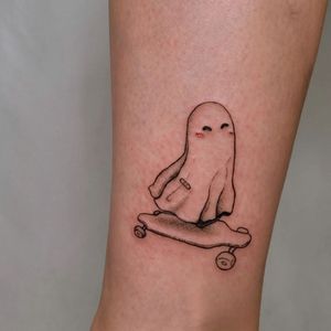 Unique blackwork tattoo of a ghost riding a skateboard, creatively illustrated by Erin on the arm. Perfect for skateboarding enthusiasts!
