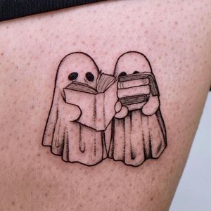 Experience the haunting beauty of an illustrative blackwork tattoo featuring a ghost emerging from a book. Expertly crafted by artist Erin.