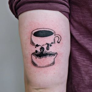 Explore the spooky side of caffeine with this blackwork ghost and coffee cup tattoo by artist Erin. Perfect for the upper arm.