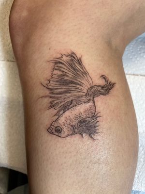 Elegant fish motif tattoo by Ermis Atzemoglou, showcasing intricate fine line work on the lower leg.