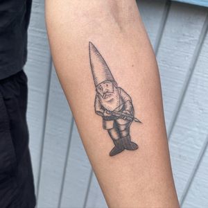 Get a unique and intricate tattoo of a dagger and dwarf on your forearm, expertly done by Ermis Atzemoglou in fine line style.