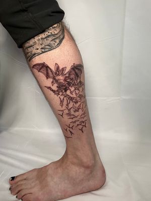 Get a sleek and stylish tattoo of a bat by renowned artist Ermis Atzemoglou on your lower leg. Perfect for fans of fine line work!