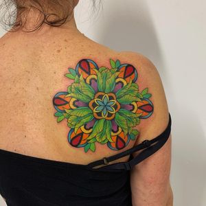 Beautiful upper back tattoo by Karen Buckley combining intricate floral design with vibrant colors.