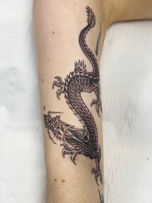 Sophie Rose Hunter brings traditional Japanese artistry to life with a fine line dragon tattoo on your arm.