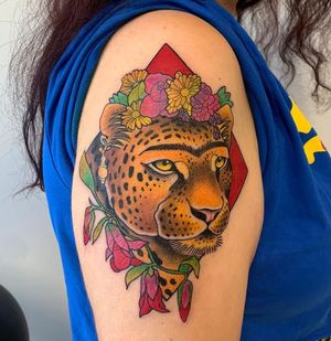 This stunning tattoo by Karen Buckley combines a fierce tiger with delicate floral elements, creating a beautiful and unique design for your upper arm.