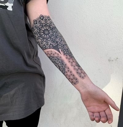 Explore the intricate beauty of dotwork in this geometric mandala tattoo on your lower arm. By talented artist Karen Buckley.