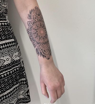 Elegant dotwork mandala design on forearm by Karen Buckley. Intricate geometric pattern for a unique and stylish tattoo.