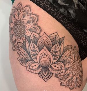 Elegant upper leg tattoo by Karen Buckley combining intricate dotwork and ornate lotus mandala design.