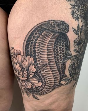 Exquisite black and gray tattoo by Karen Buckley featuring a snake and cobra motif on the upper leg.