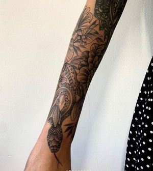 Karen Buckley's stunning sleeve tattoo features intricate dotwork snake, floral motifs and patterns.