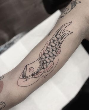 Exquisite fish motif tattoo by Federico Colantoni on the upper arm, showcasing intricate detail and artistry.