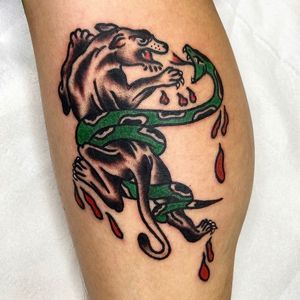 Express your dark side with this classic tattoo design featuring a snake and rat motif on your lower leg. Expertly done by tattoo artist Alessandro Lanzafame.