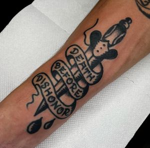 Get a bold and traditional dagger tattoo with a meaningful quote by Alessandro Lanzafame on your forearm.