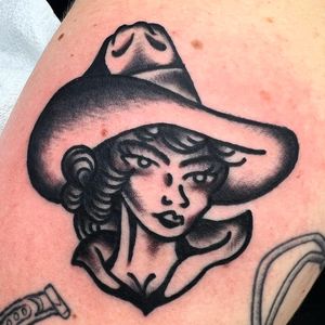 Get inked with a stunning cowgirl design by Alessandro Lanzafame. This traditional style tattoo is perfect for your arm.