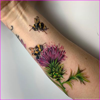 Vibrant watercolor style tattoo featuring a bee and flower design by artist Karen Buckley. Perfect for nature lovers.