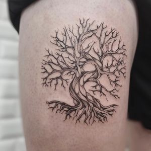 Embrace nature with a stunning blackwork tree tattoo on your upper arm. Designed by Polina for a unique and artistic touch.