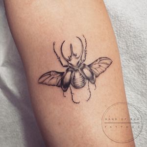 Get a stunning blackwork beetle tattoo on your forearm by Raa, showcasing intricate details and bold design.