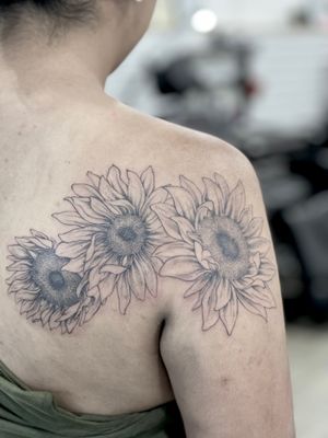 This stunning blackwork and illustrative style tattoo features a beautifully detailed sunflower, perfectly placed on the upper back. Created by the talented artist Lawrence.
