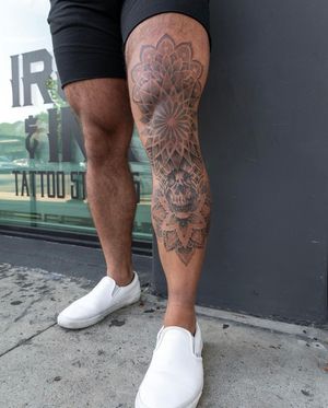 Lawrence creates a mesmerizing dotwork design combining a skull motif with ornamental mandala and geometric patterns on the knee.
