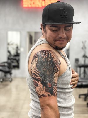 Experience the beauty of Japanese art with a mesmerizing dragon and flower design by the talented Kotaro. Perfect for your upper arm!